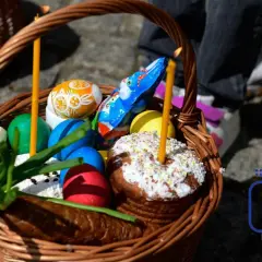 Koszyk wielkanocny z pisankami, babką i świecami. Zastanawiasz się, dlaczego święta wielkanocne są ruchome?