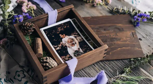 Drewniane pudełko z fotografiami ślubnymi i wstążką. Idealny prezent na papierową rocznicę, pełen wspomnień i miłości.