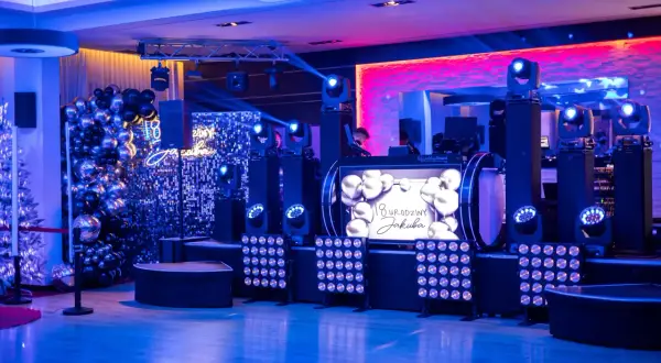 Efektowne atrakcje na 18 urodziny na sali: DJ, balony, światła i ekran z życzeniami.