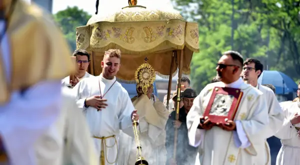 Procesja Bożego Ciała 9 czerwca. Wierni niosą monstrancję pod baldachimem, towarzyszą im księża w białych szatach i kadzidło.
