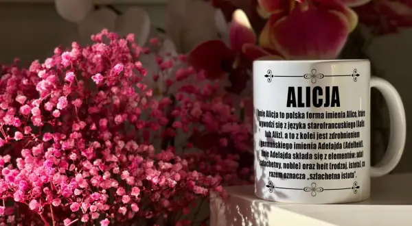 Kiedy są imieniny Alicji, warto podarować jej kubek z opisem imienia. Na zdjęciu kubek z napisem "Alicja" i ozdobnymi kwiatami.