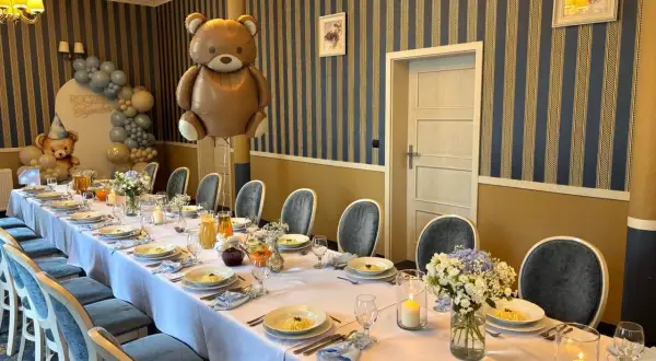 Uroczysta sala na 30 urodziny z balonami w kształcie misia, ozdobionym stołem i nakryciami.