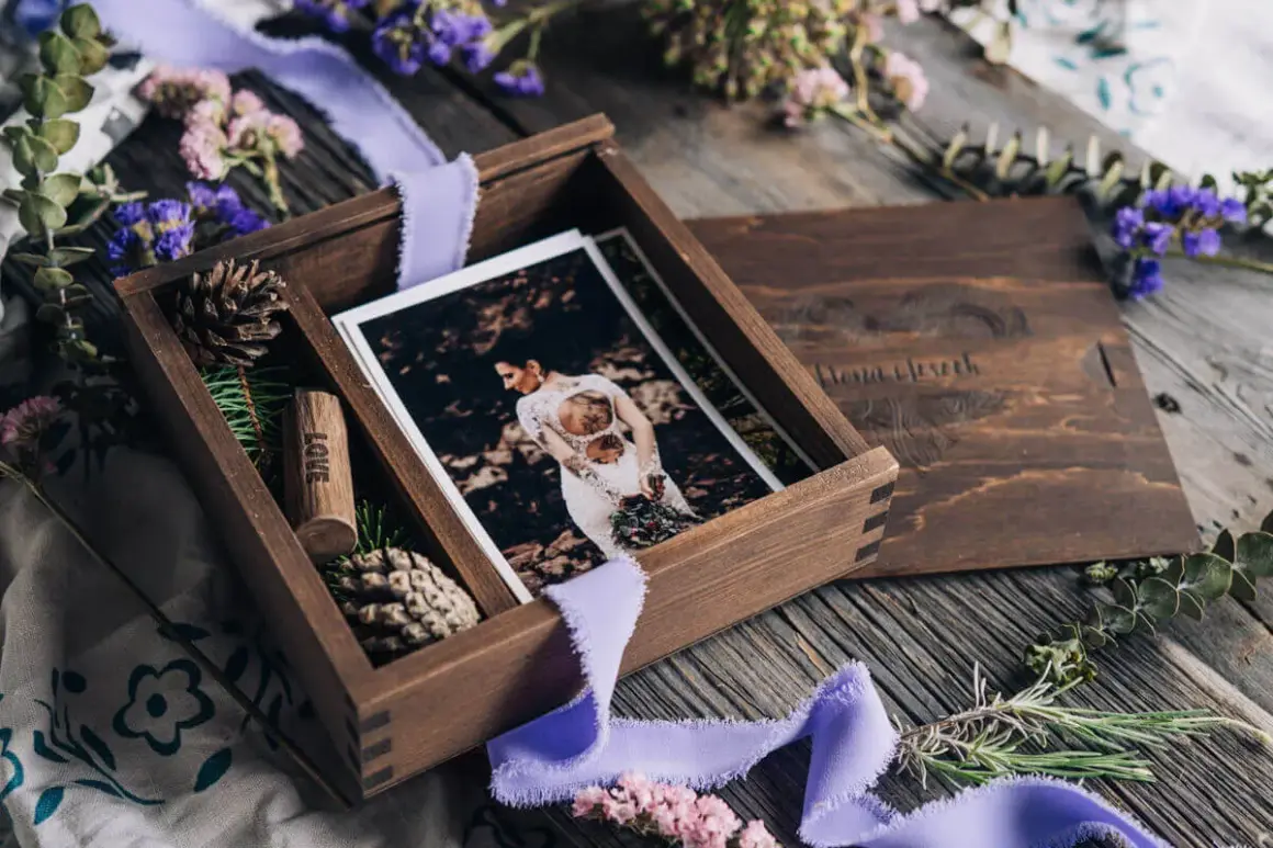 Drewniane pudełko z fotografiami ślubnymi i wstążką. Idealny prezent na papierową rocznicę, pełen wspomnień i miłości.