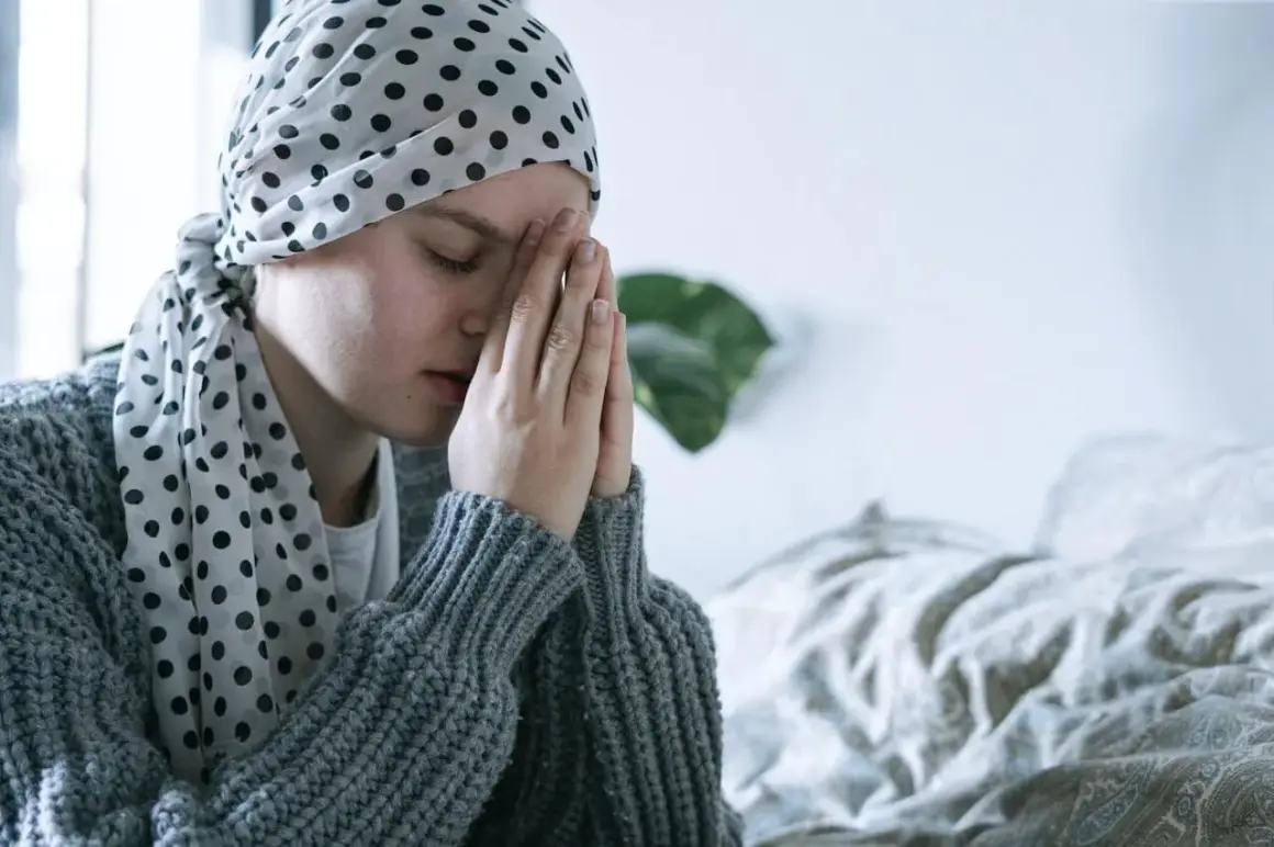 Osoba w chuście z kropkami modli się, szukając pocieszenia w modlitwie do św. Peregryna.