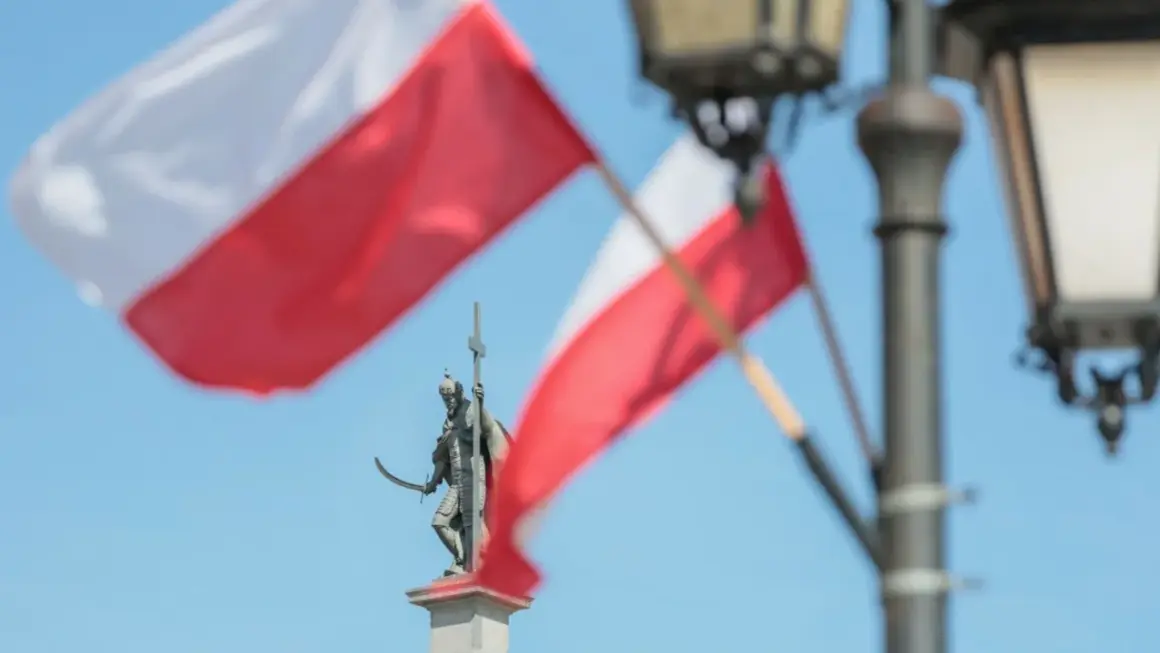 Pomnik rycerza z mieczem i krzyżem na tle polskich flag i latarni.