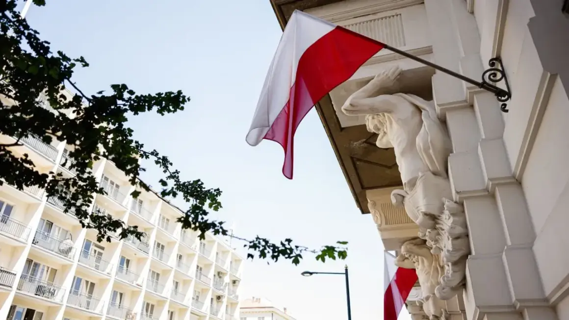 Biało-czerwona flaga powiewa na tle jasnego nieba, obok rzeźb atlantesów. Czy 2 maja jest wolny?