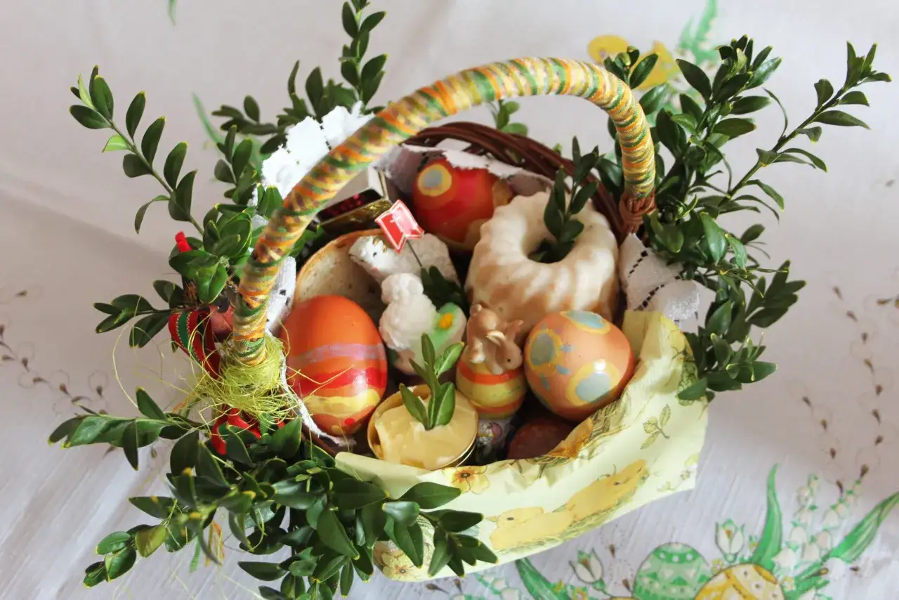 Wesołych Świąt! W koszyczku wielkanocnym: pisanki, baranek, babka, chleb i bukszpan.