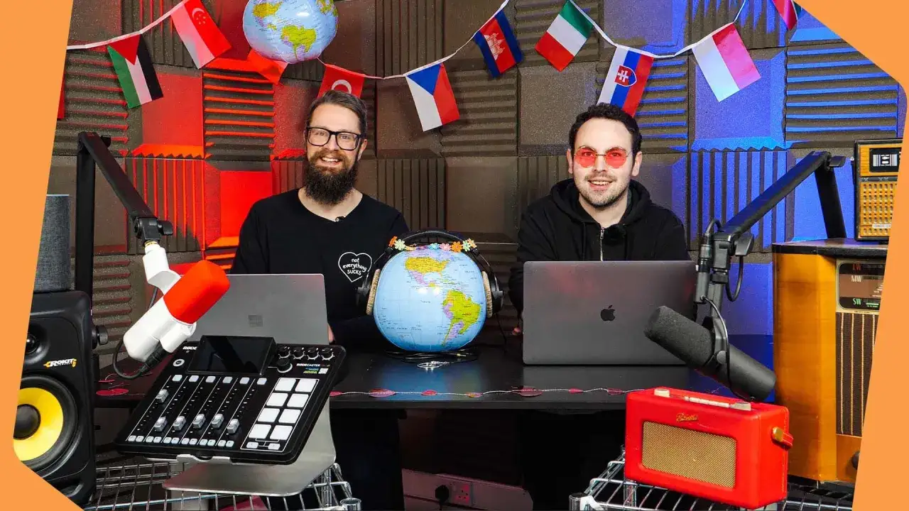 Dwóch mężczyzn w studiu z globusem i flagami. Czy 13 luty jakie święto? Może Międzynarodowy Dzień Radia?