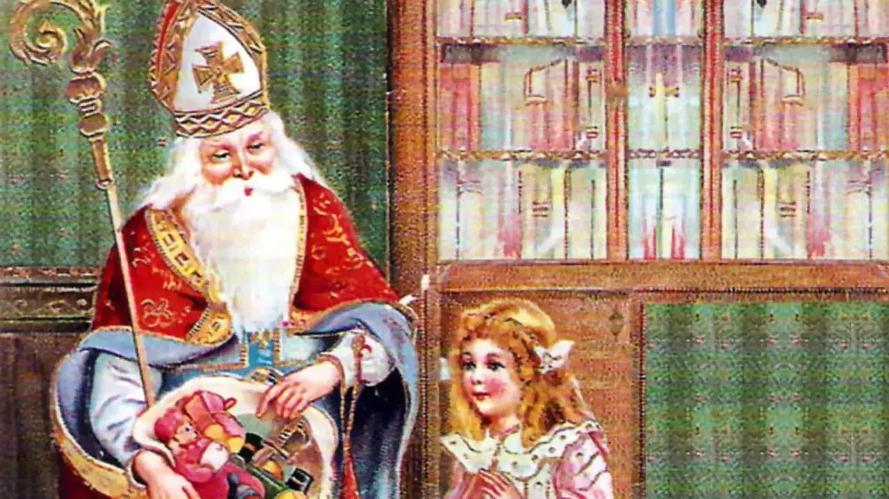 Święty Mikołaj w bogatych szatach z pastorałem i koszem pełnym zabawek, obok niego mała dziewczynka z dłońmi złożonymi w modlitwie.